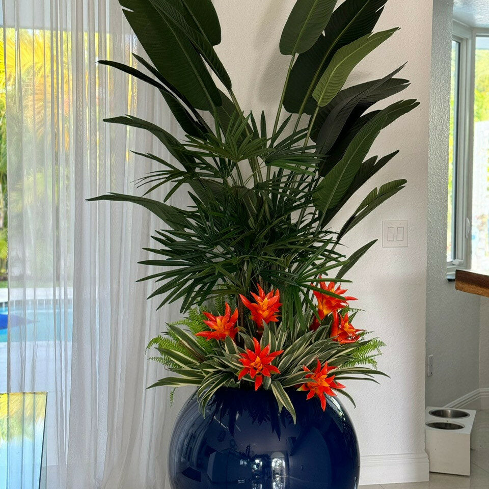 Tropical plant arrangement in cobalt blue Globe pot.